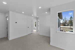 Spare room featuring recessed lighting, light carpet, and healthy amount of natural light