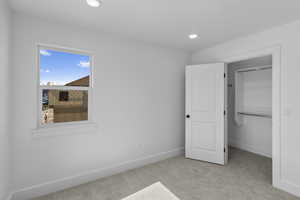 Unfurnished bedroom with carpet flooring, a spacious closet, and recessed lighting