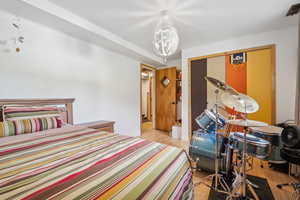 Bedroom featuring wood finished floors, a chandelier, and a closet