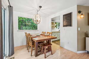 Dining area featuring light wood finished floors and a chandelier