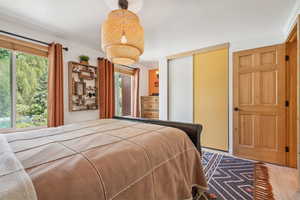 Bedroom with crown molding, a closet, and wood finished floors