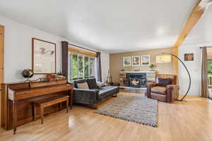 Living area with wood finished floors and a stone fireplace