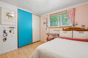Bedroom with wood finished floors and baseboards