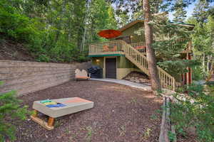 Rear view of house featuring stairs, a wooden deck, and a garage