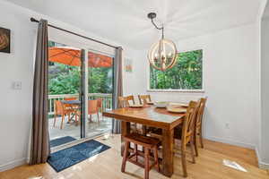 Dining space with a chandelier, healthy amount of natural light, and light wood-style flooring