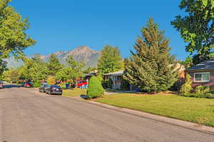 View of asphalt street featuring a mountain view and curbs