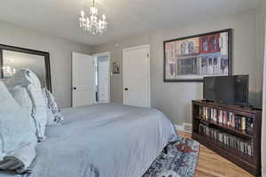 Bedroom with a chandelier and wood finished floors