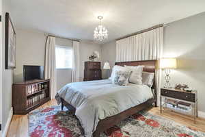 Bedroom featuring a chandelier and wood finished floors