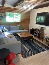 Living room featuring rustic walls and wood finished floors