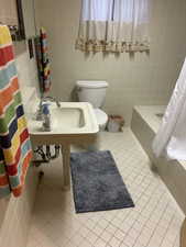 Bathroom featuring tile walls, tile patterned floors, and tiled shower