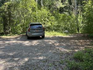 View of parking / parking lot featuring a view of trees