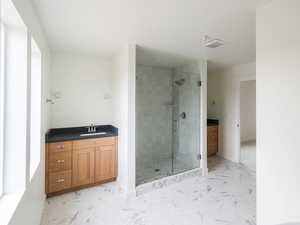 Bathroom with 2 separate sinks, a shower, and free standing tub.