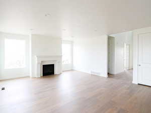 Unfurnished living room with light wood finished floors and a fireplace