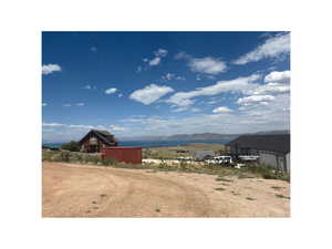 View of yard with a mountain view, dirt driveway, and an attached garage