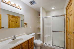 Bathroom featuring vanity, a shower stall, tile patterned flooring, and a textured ceiling