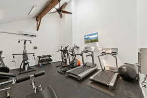 Exercise room with ceiling fan, beamed ceiling, a wall mounted air conditioner, and high vaulted ceiling