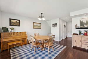Dining area with dark wood-style flooring, a chandelier, and recessed lighting