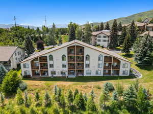 Rear view of property with a mountain view and stucco siding