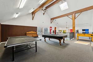 Recreation room with ceiling fan, carpet floors, a skylight, high vaulted ceiling, and billiards table