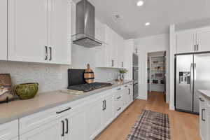 Kitchen with double ovens, gas cooktop and hoodvent.