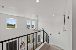 Curved staircase with sconces and chandelier