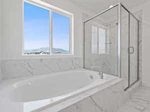 Bathroom featuring a bath and a shower.