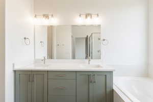 Full bathroom with a bath, double vanity, and a shower stall