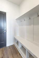 Mudroom featuring dark wood-type flooring and baseboards