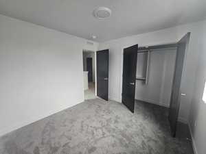 Unfurnished bedroom featuring carpet and a closet