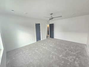 Spare room with ceiling fan, carpet floors, and a textured ceiling
