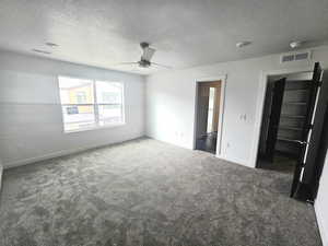 Unfurnished bedroom with carpet floors, a textured ceiling, and ceiling fan