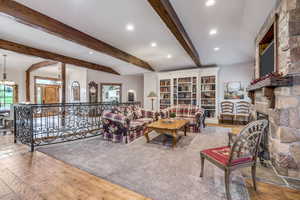 Living area featuring hardwood / wood-style flooring, beamed ceiling, recessed lighting, and a fireplace