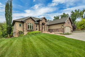 Craftsman inspired home with stone siding, a front yard, driveway, and stucco siding