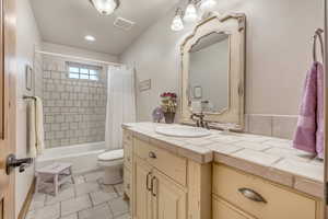 Full bathroom with vanity, shower / bathtub combination with curtain, recessed lighting, and tile patterned floors