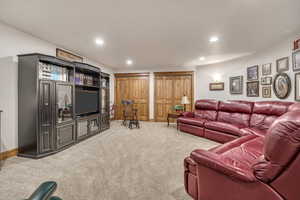 Living area with carpet floors and recessed lighting