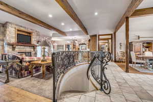 Stairs featuring beam ceiling, a fireplace, a chandelier, and recessed lighting
