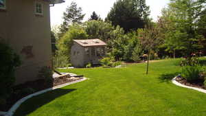 View of grassy yard featuring an outdoor structure