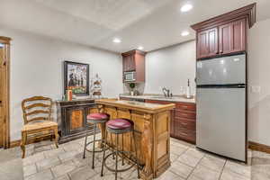 Kitchen featuring stainless steel appliances, light countertops, recessed lighting, a kitchen island, and light tile patterned floors