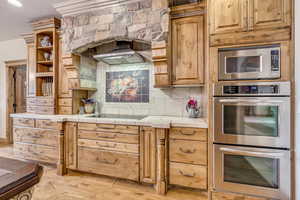 Kitchen featuring stainless steel appliances, decorative backsplash, tile counters, open shelves, and recessed lighting