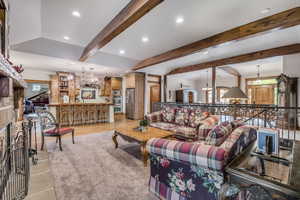 Living area featuring beamed ceiling, recessed lighting, and a chandelier