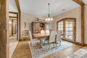 Dining room with french doors, a chandelier, and light wood-style floors