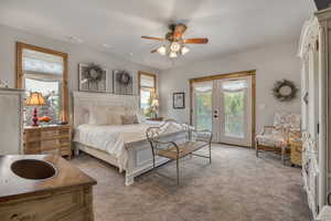 Bedroom with light carpet, french doors, access to exterior, and ceiling fan