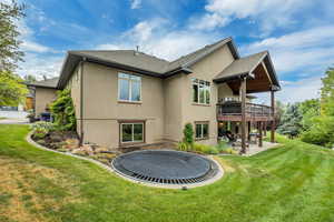Rear view of property featuring a patio, stucco siding, a lawn, and a shingled roof