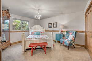 Bedroom featuring a chandelier, light colored carpet, and a closet