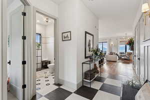 Corridor with light flooring and a chandelier