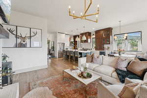 Living area featuring a chandelier, light wood-style floors, beverage cooler, and recessed lighting