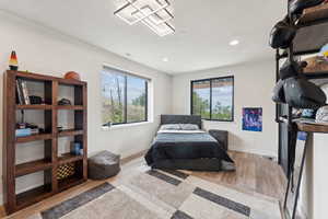 Bedroom featuring multiple windows, wood finished floors, and recessed lighting