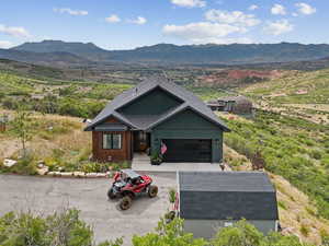 View of front of home featuring a mountain view, a garage, concrete driveway, and roof with shingles