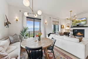 Dining area featuring a chandelier, light wood-style floors, and a glass covered fireplace