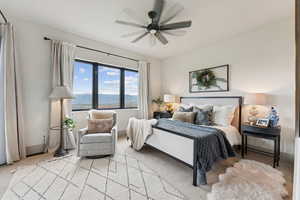 Carpeted bedroom with a ceiling fan and baseboards